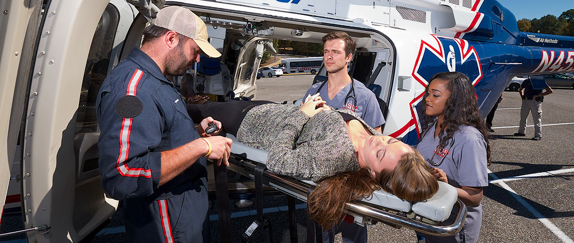 Nursing students assist with loading patient into helicopter