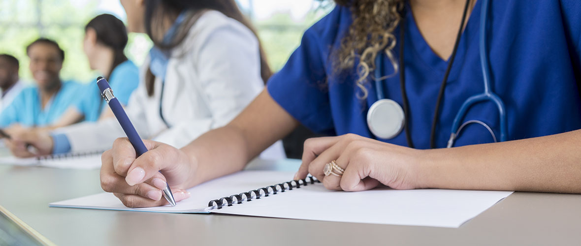 Nursing student writing in notebook