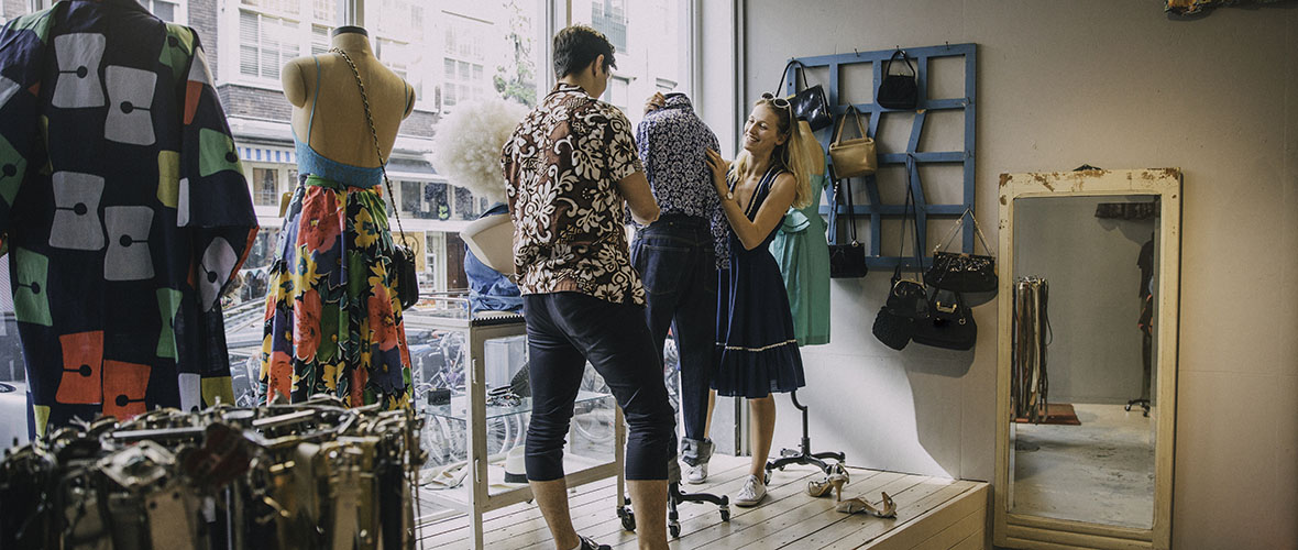 Merchandising students dressing mannequin in store window