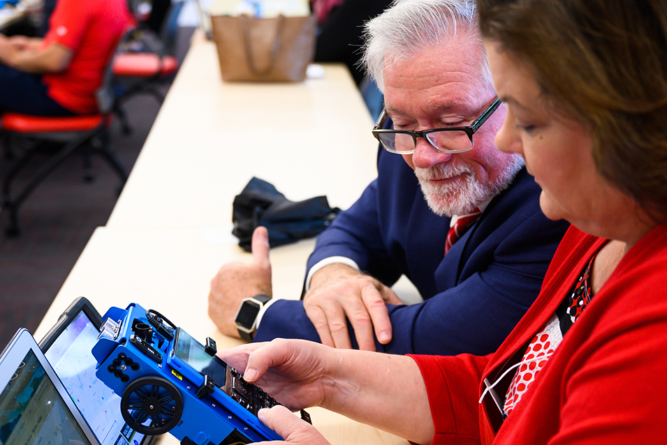 Doctor Turner checks out a robotic device with Doctor Gretchen Richards at a Core teacher workshop