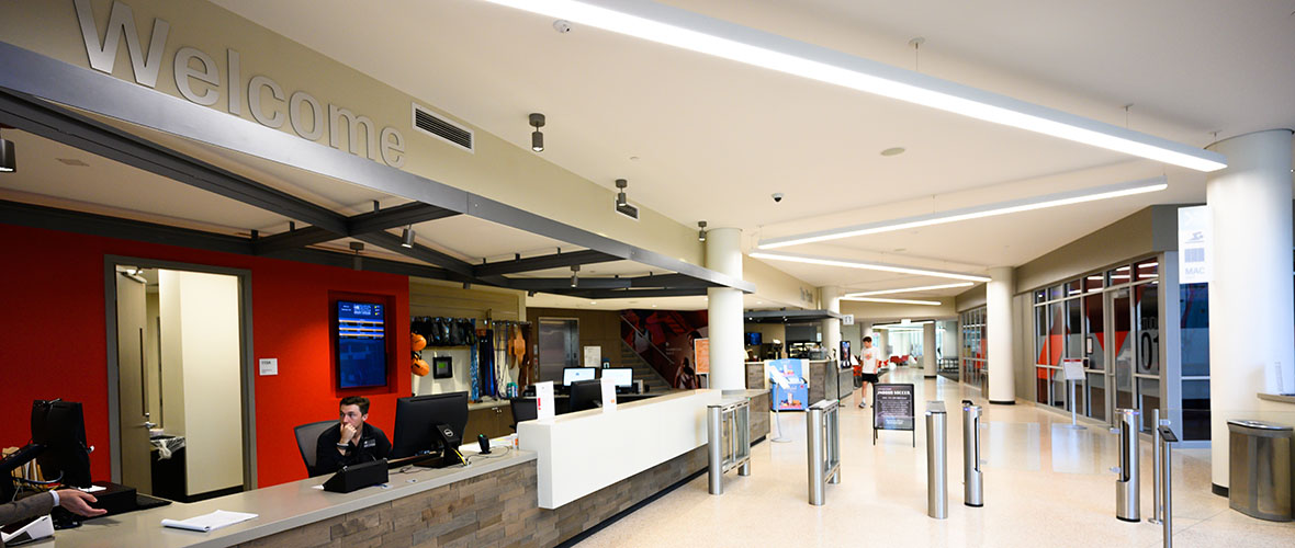 Student staff sit at the welcome desk adjacent to the rec center lobby.