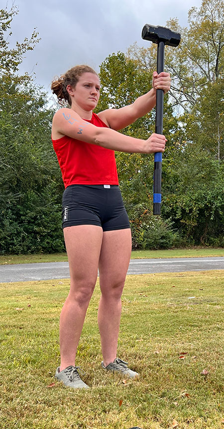 A female Strong One competitor participates in the hammer hold